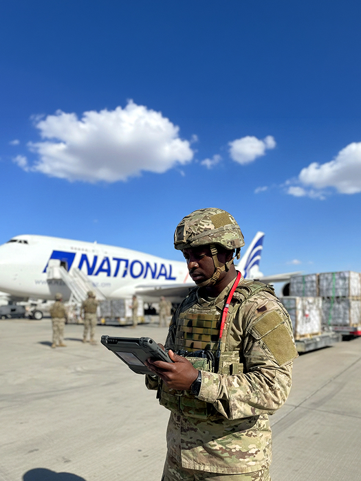 A solider standing near an airplane