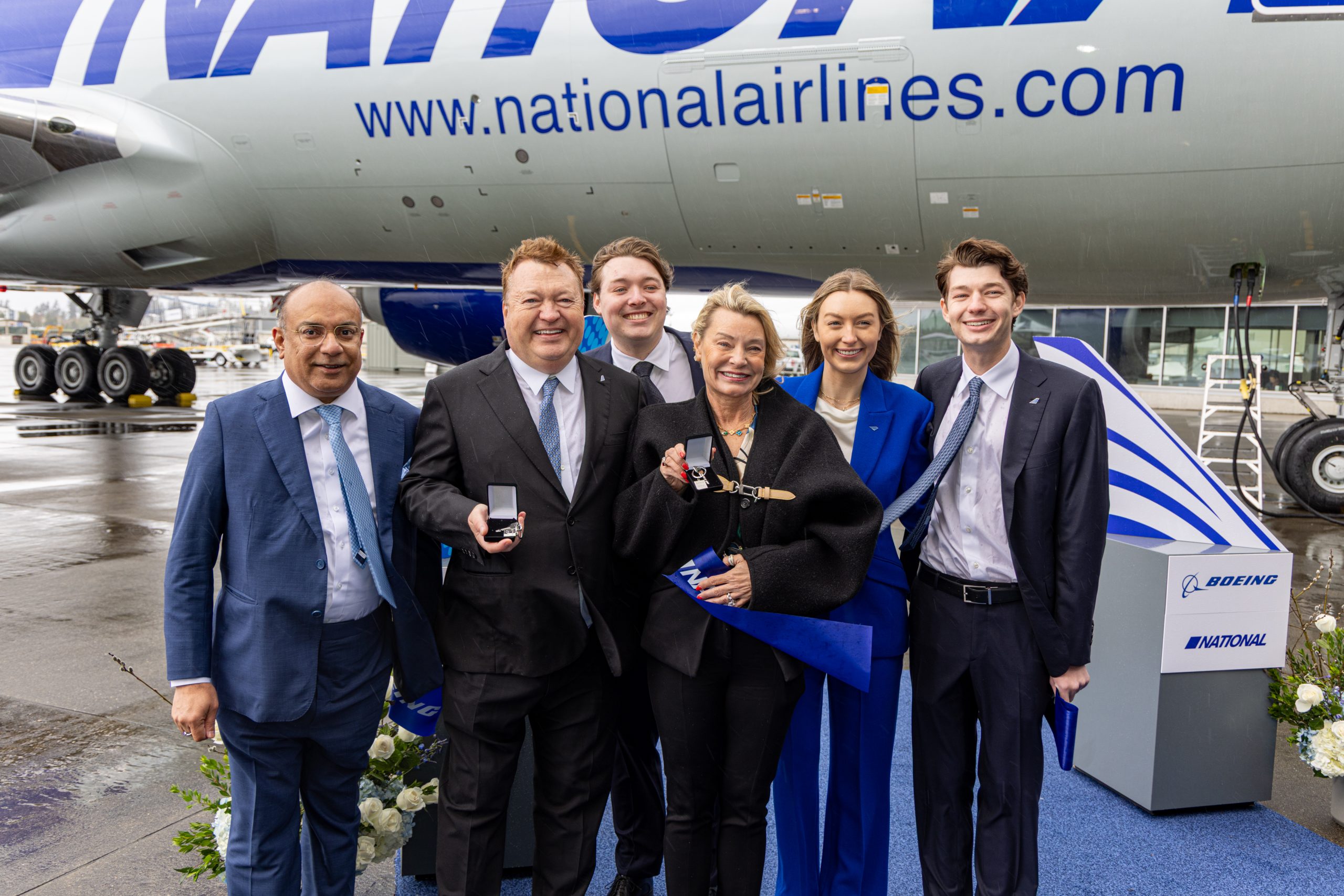 A group of people beside an airplane