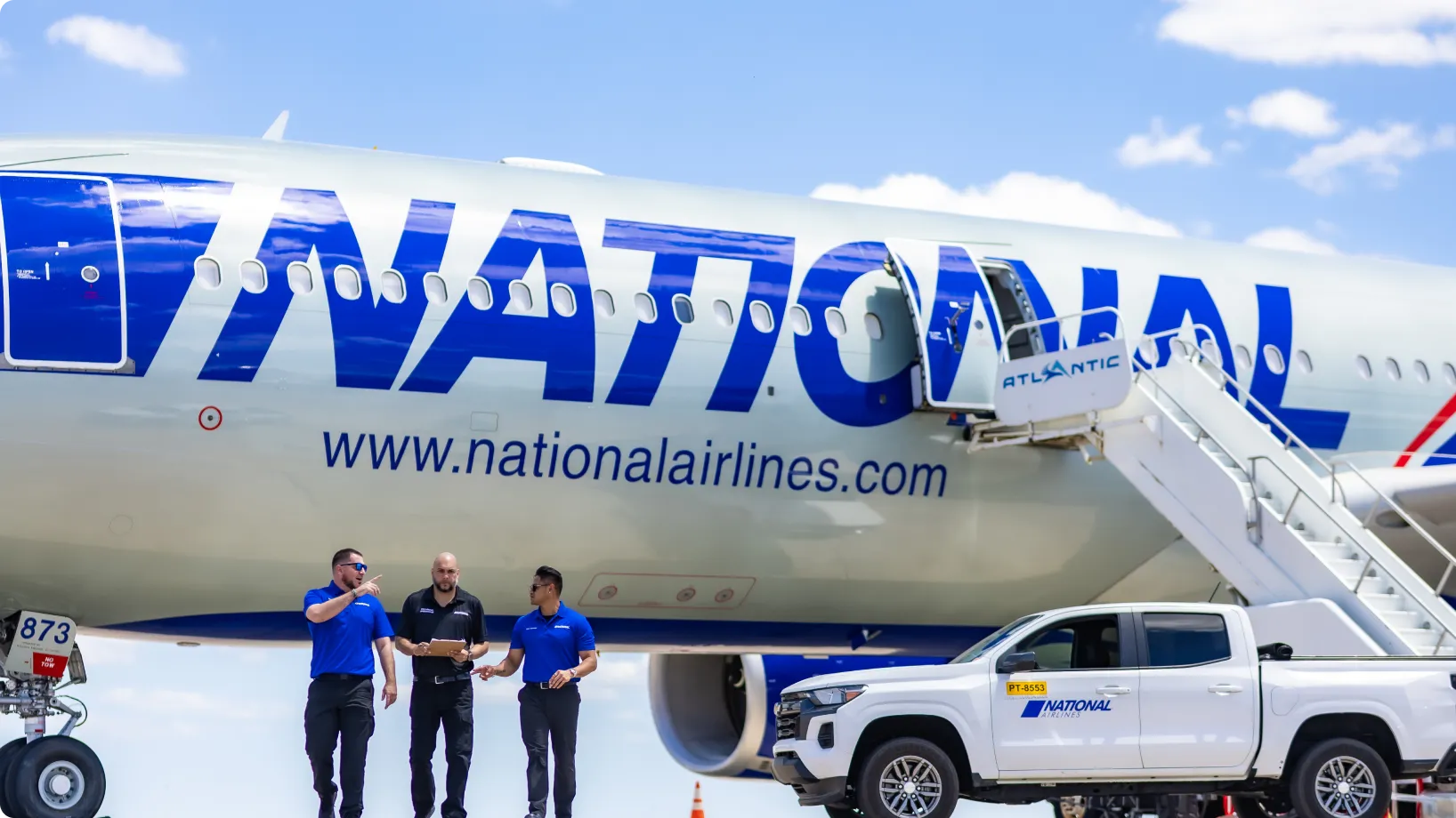 A group of workers beside an airplane