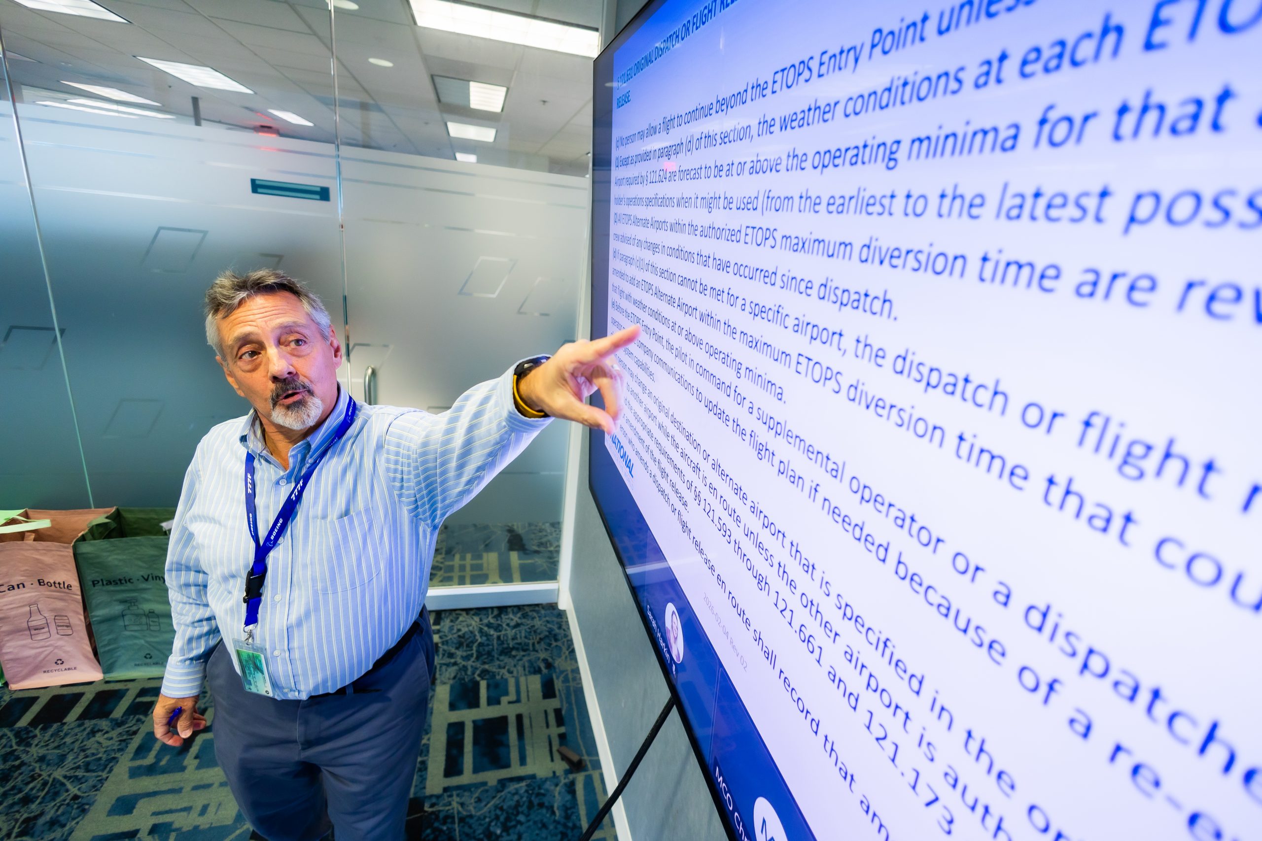 A person motioning toward a large screen