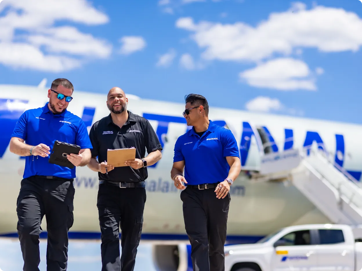 A group of workers beside an airplane